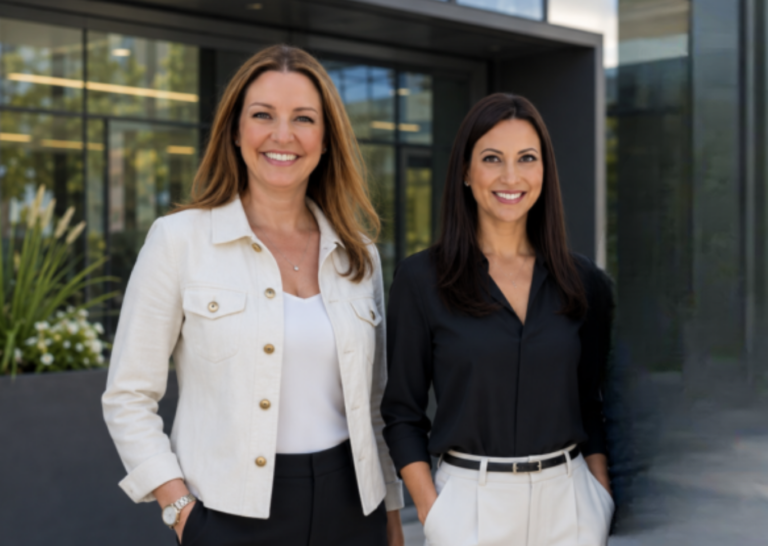 Leanne Berthiaume and Jessica Miller of Rock Spring Real Estate Solutions standing outside a modern office building